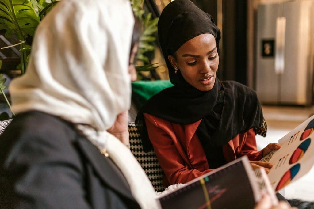 Two people reviewing printed brand materials at a table